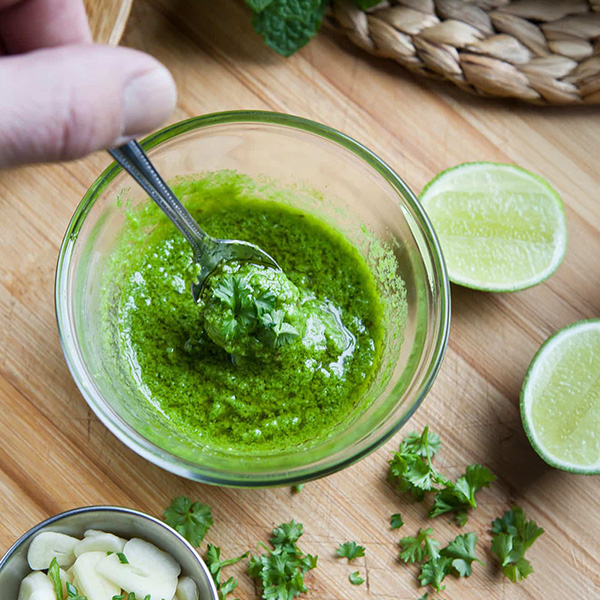 Engelse greensauce in een rustiek glazen potje, gemaakt met zuring, azijn en honing, geserveerd met verse munt en traditionele Britse ingrediënten.