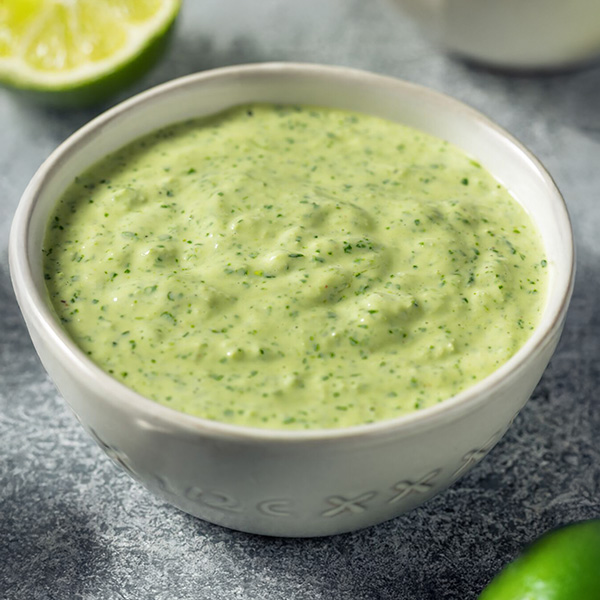 Franse sauce verte, een romige groene saus met dragon, peterselie en limoensap, geserveerd in een keramisch schaaltje met stukjes oud brood